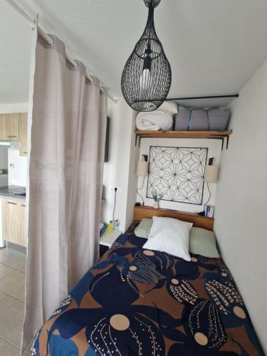une chambre avec un lit et un lustre dans l'établissement Ambre Appart-Wifi-Terrasse-Parking-Terrasse-2 couchages, à La Rochelle