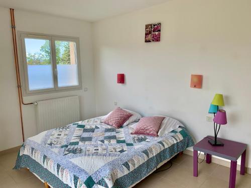 une chambre avec un lit, une table et une fenêtre dans l'établissement Grande maison vue sur lac à Pelleautier très calme, à Pelleautier
