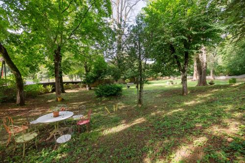a picnic table and chairs in a park with trees at VILLA NOTRE DAME face au Château fort in Sedan
