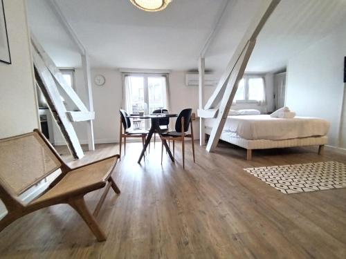 une chambre avec un lit, une table et des chaises dans l'établissement Le Nid Citadin - Ultra Calme - Terrasse avec Vue, à Pau