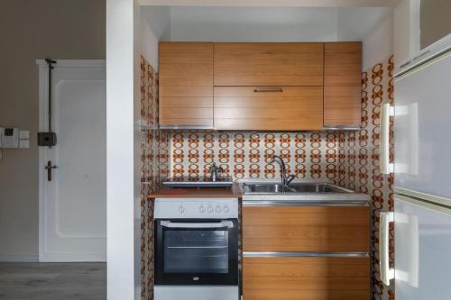 a kitchen with wooden cabinets and a stove at i-HOMES Luxury Suite San Martino in Padova