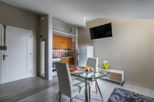 a dining room with a table and chairs and a kitchen at i-HOMES Luxury Suite San Martino in Padova