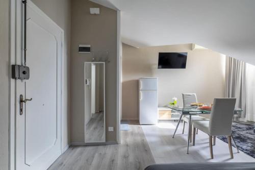 a kitchen and dining room with a table and a refrigerator at i-HOMES Luxury Suite San Martino in Padova