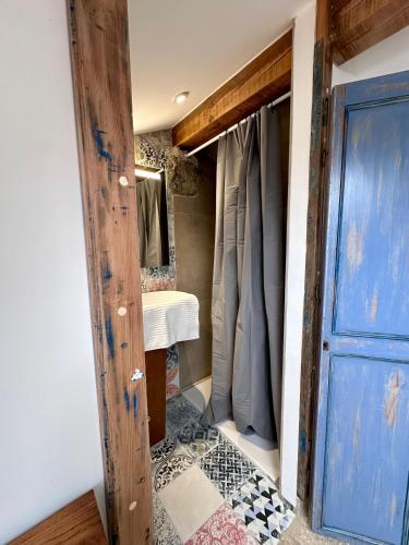 a bathroom with a door and a tiled floor at Maison cantonnière in Sartène