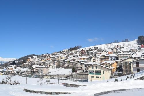 a snow covered village on a hill with houses at Castello Mountain Lake Iseo Hospitaty in Bossico