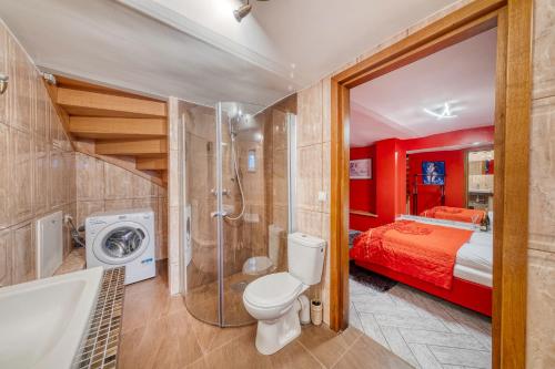 een badkamer met een toilet en een douche en een bed bij Apartamenty Firfas 2 in Bydgoszcz