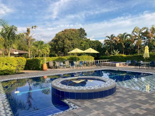 a swimming pool with a table and chairs next to it at Villa Thiago Finca in Armenia