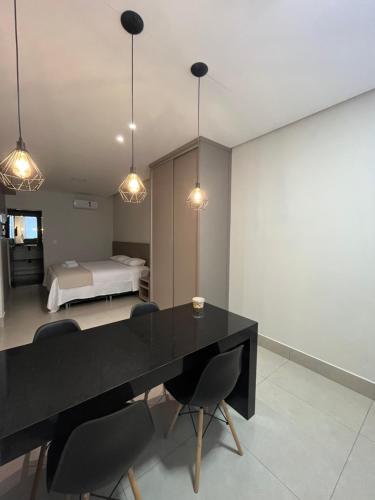 a dining room with a black table and chairs at ESCARPAS FLATS in Capitólio