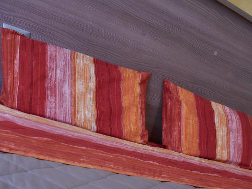 a close up of a wooden bed with colorful blankets at BnB Anna e Leo - Casa di Anna in Pietra Montecorvino