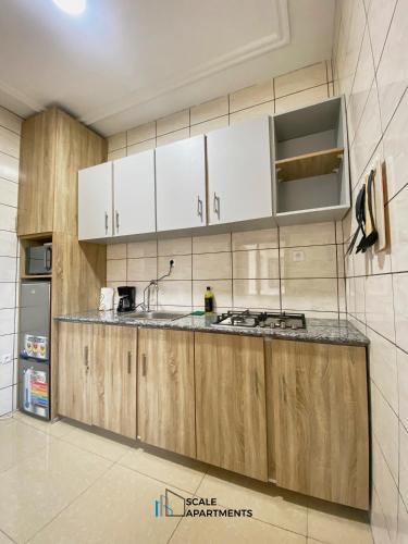 a kitchen with white cabinets and a counter top at Scale Apartments in Douala