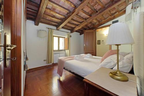 a bedroom with a bed and a lamp on a table at Classic roman home next to Popolo Square in Rome
