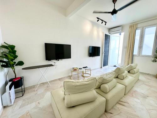 a living room with a couch and a flat screen tv at Stylish Cozy Landed Jelutong 3Room2bath4park 10pax in Jelutong