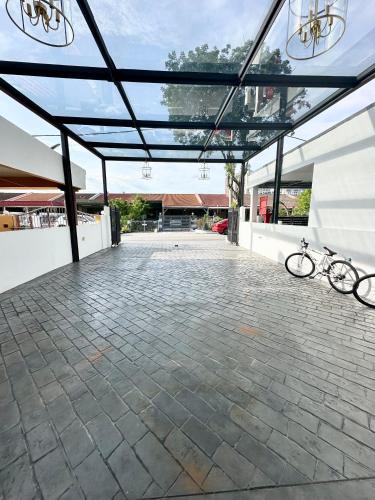 a patio with a bike parked under a glass roof at Stylish Cozy Landed Jelutong 3Room2bath4park 10pax in Jelutong