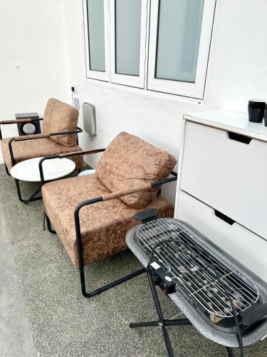a living room with two chairs and a grill at Stylish Cozy Landed Jelutong 3Room2bath4park 10pax in Jelutong