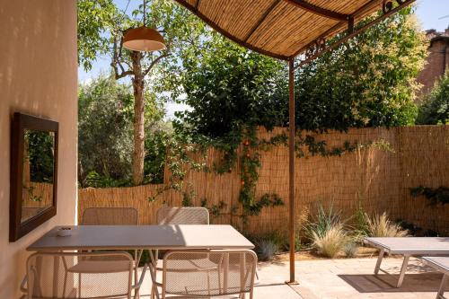 a patio with a table and chairs and an umbrella at Fontarcella, Heart & Roots in Petrignano sul Lago