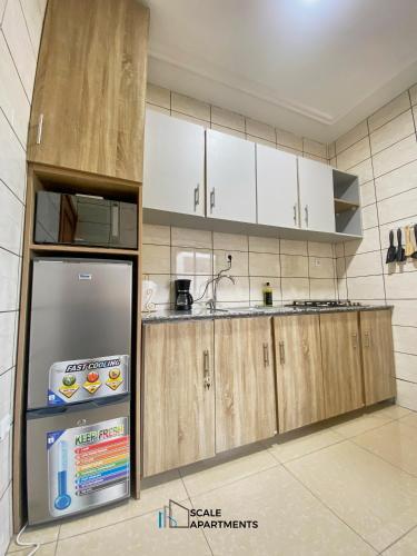 a kitchen with white cabinets and a refrigerator at Scale Apartments in Douala