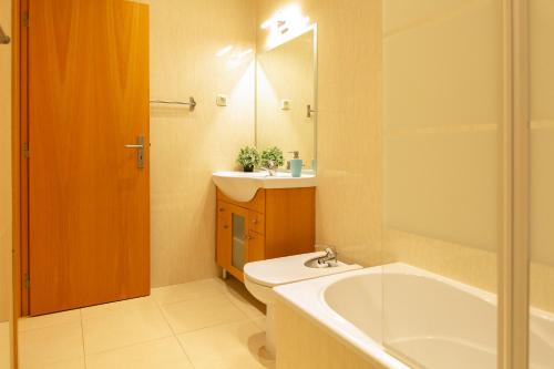 a bathroom with a tub and a sink and a toilet at Sunny Condo-Pool by Algarve Dream Holidays in Albufeira