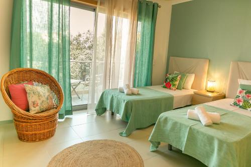 a room with two beds and a chair and a window at Sunny Condo-Pool by Algarve Dream Holidays in Albufeira