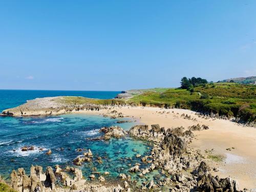 a group of people on a beach near the ocean at APARTAMENTOS RURALES El Llagar de Cue in Llanes