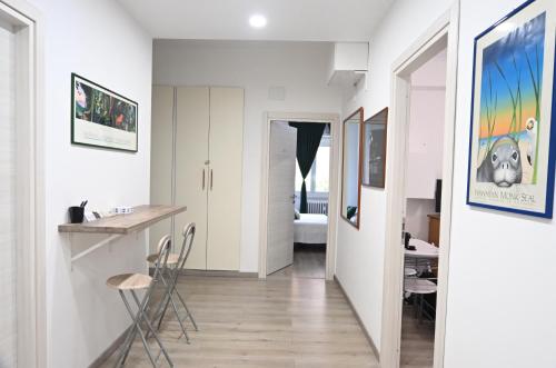 a hallway with white walls and a kitchen with chairs at Appia Antica Guest House in Rome