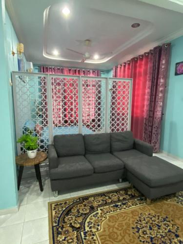 a living room with a couch and red curtains at Seri Idaman Guest House (Pasir Mas) in Kampong Taman
