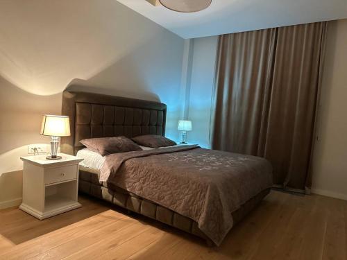 a bedroom with a bed and a night stand with a lamp at Sea Breez The Grant Hotel Apartment in Bilgah
