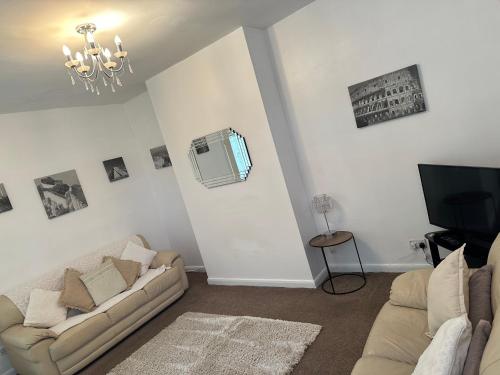 a living room with two couches and a tv at Home and Away, close to Preston Park and Yarm High street in Stockton-on-Tees