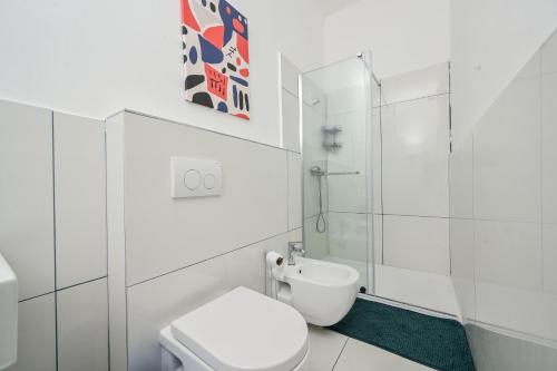 a white bathroom with a toilet and a shower at Hostel Fun in Rijeka