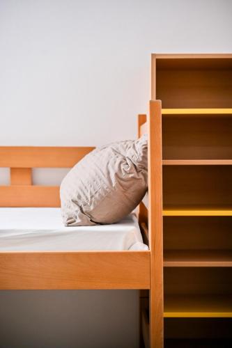 a bunk bed with a pillow and a book shelf at Hostel Fun in Rijeka