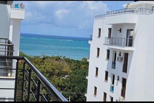 a view of the ocean from a balcony of a building at Azure 3bdrm beachfront at jumeirah palm resort nyali in Bamburi