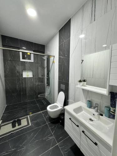a bathroom with a shower and a toilet and a sink at Azure 4bdrm beachfront at jumeirah palm resort nyali in Bamburi