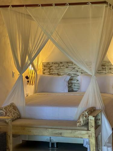 a bedroom with a bed with a canopy at Rio Da Barra Villa Hotel in Trancoso