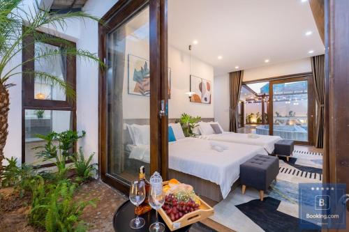 Cette chambre comprend un lit et une table avec des fruits. dans l'établissement Cối Xoay Gió Trệt Không Lầu - 6 Phòng Ngủ - Bida - Karaoke Phòng Lạnh - Gần Biển Bãi Sau Vũng Tàu, à Vung Tau