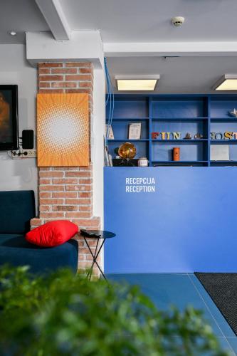 a red pillow on a couch in a room with blue cabinets at Hostel Fun in Rijeka