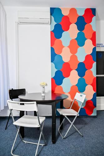 a table and chairs in a room with a colorful wall at Hostel Fun in Rijeka