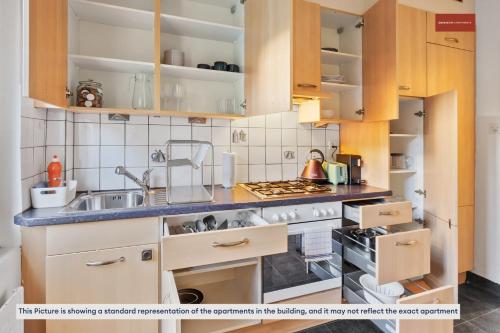 a kitchen with wooden cabinets and a sink at Apartment in the heart of Oerlikon in Zürich