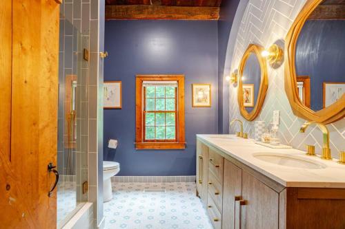 a blue bathroom with a toilet and a sink at Unique Fully Restored Landmark Barn in Hudson in Claverack