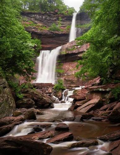 a waterfall on the side of a mountain with rocks at Unique Fully Restored Landmark Barn in Hudson in Claverack