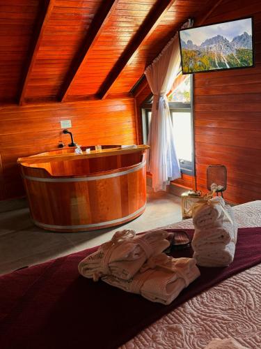 a bathroom with a tub and a tv in a room at Capanna del Vale - Refúgio & Degustação no Vale dos Vinhedos in Bento Gonçalves