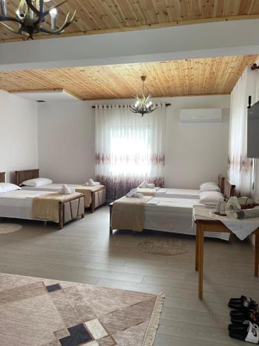 ベラトにあるGeorgemishel Guest Houseのベッド2台とシャンデリア付きの広いベッドルーム1室が備わります。
