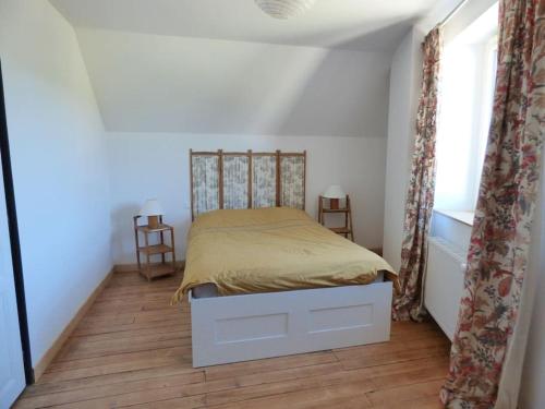 une chambre avec un lit dans une pièce blanche dans l'établissement Maison de vacances ideale - La Mariniere du Mesnil, à Le Mesnil