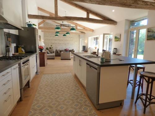 une grande cuisine avec un comptoir et un salon dans l'établissement Maison de vacances ideale - La Mariniere du Mesnil, à Le Mesnil