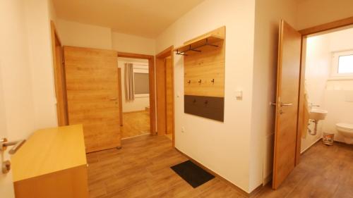 a bathroom with a wooden door and a hallway at Ferienwohnung Königsberg in Tieschen