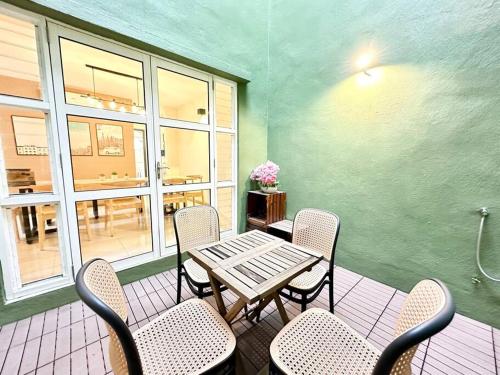 a patio with a table and chairs and a table and windows at Karpal Singh Drive Seaside Georgetown 4BR-15pax by 3C in George Town