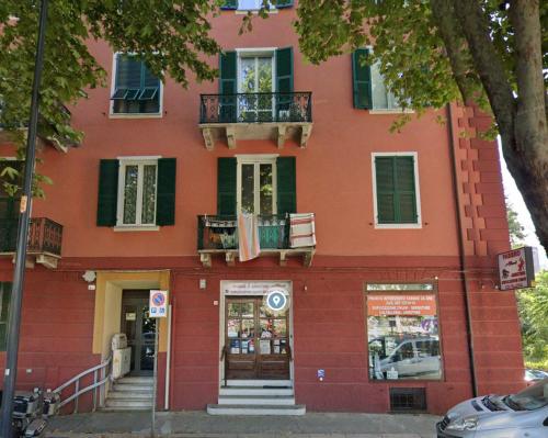 a red building with a balcony on the side of it at Bed'n Fast Savona in Savona