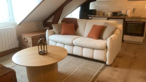 un salon avec un canapé et une table dans l'établissement Le Cocon d Auguste, au Havre