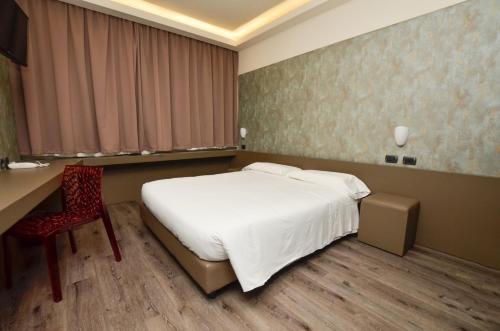 a bedroom with a bed and a desk and a chair at The Gate Hotel - Firenze Nord in Sesto Fiorentino