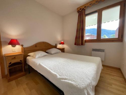 une chambre avec un lit blanc et une fenêtre dans l'établissement Appartement 1 ch, piscines, parking, animaux acceptés - FR-1-624-107, à Samoëns