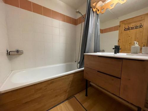 une salle de bain avec une baignoire et un lavabo et une baignoire dans l'établissement Appartement 1 ch, piscines, parking, animaux acceptés - FR-1-624-107, à Samoëns