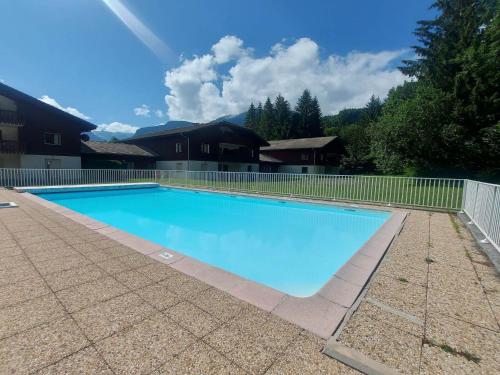 une grande piscine bleue entourée d'une clôture. dans l'établissement Appartement 1 ch, piscines, parking, animaux acceptés - FR-1-624-107, à Samoëns